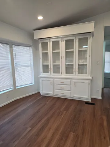 Built-in white cabinetry with glass display doors and brass hardware