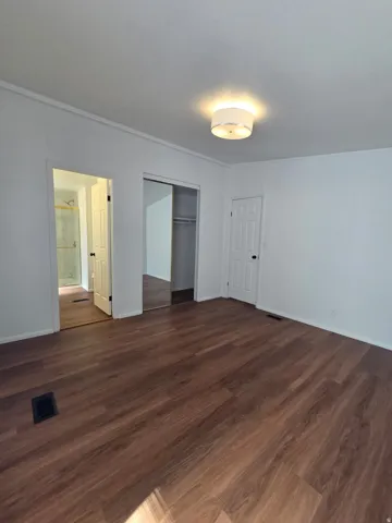 Spacious room featuring white walls, and a contemporary flush-mount ceiling light