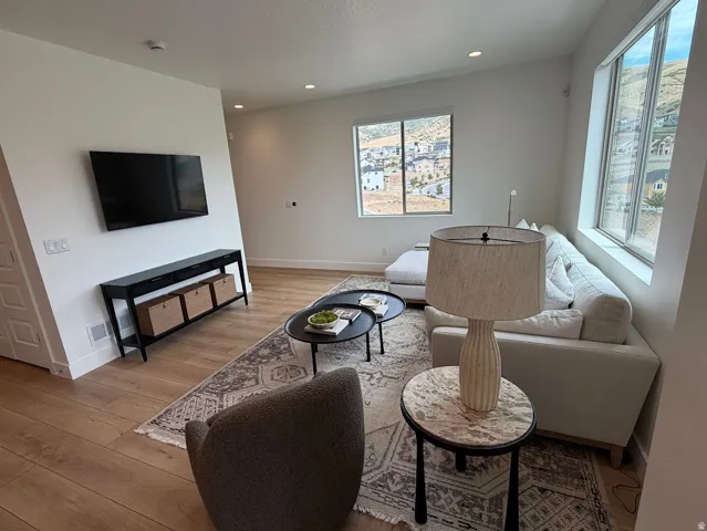Living area featuring wood-finish flooring, recessed lighting, and large picture windows