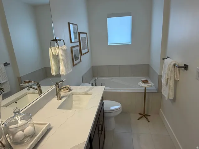 Bathroom featuring a dual vanity with a light-colored countertop, undermount sinks, and brushed nickel fixtures