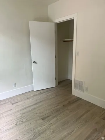 Room featuring wood-finish flooring, white baseboards, and a neutral wall palette