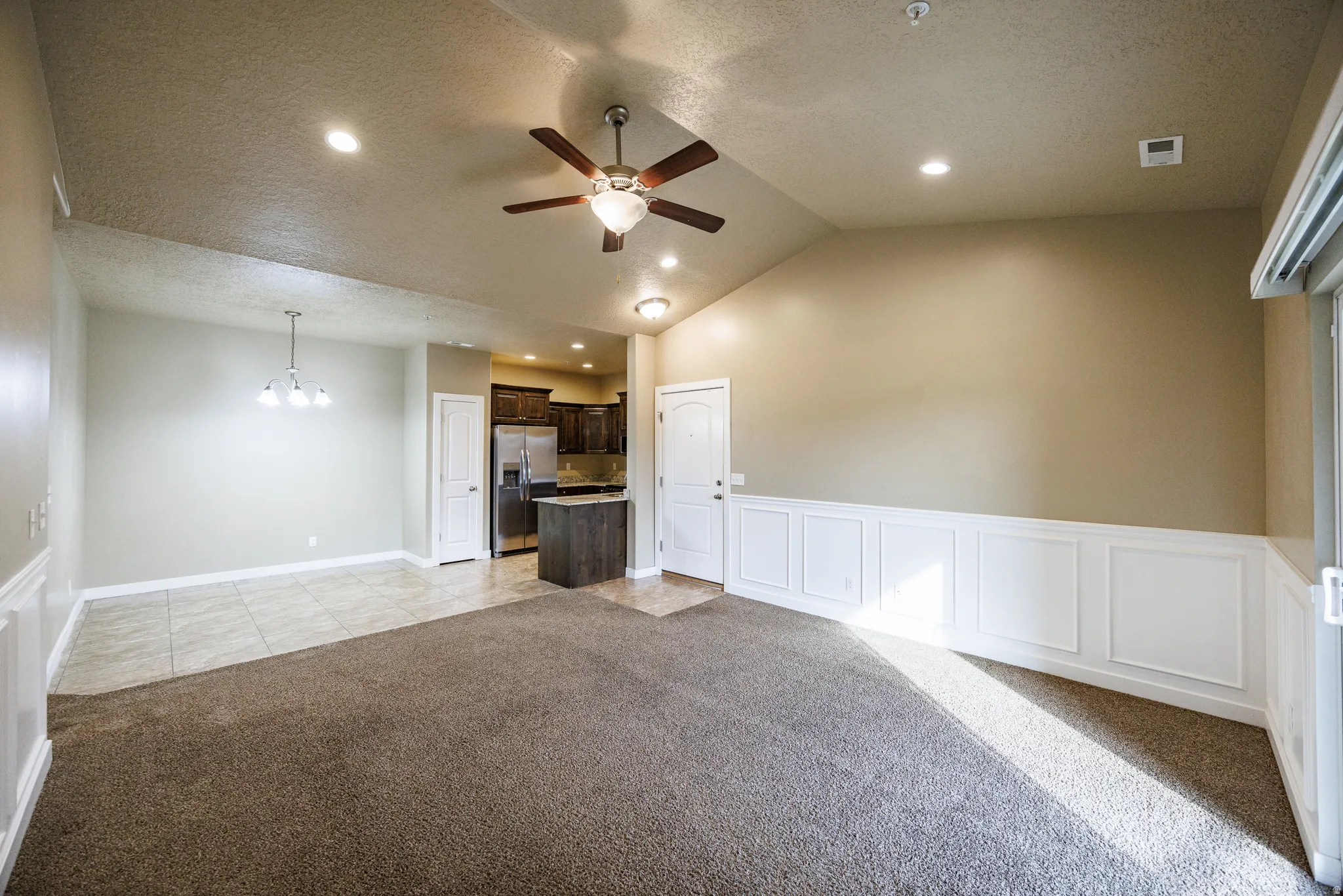 Open-concept living area with vaulted ceilings and recessed lighting