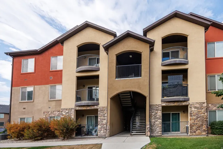 Multi-story building featuring a stucco exterior with stone accents