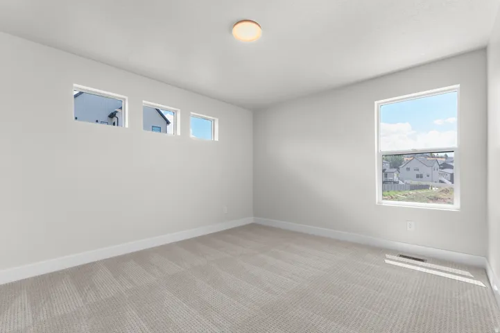 Neutral interior with light gray walls, patterned carpet flooring, and white baseboards