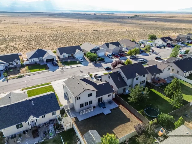 Suburban street with single-family homes featuring a variety of architectural styles, dark shingle roofs, and attached garages