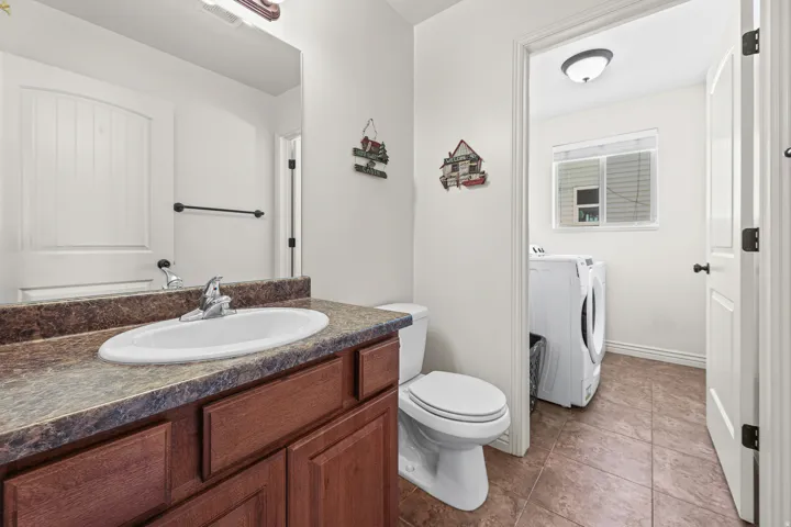 Bathroom featuring a vanity with a laminate countertop, undermount sink, and wood-finish cabinetry