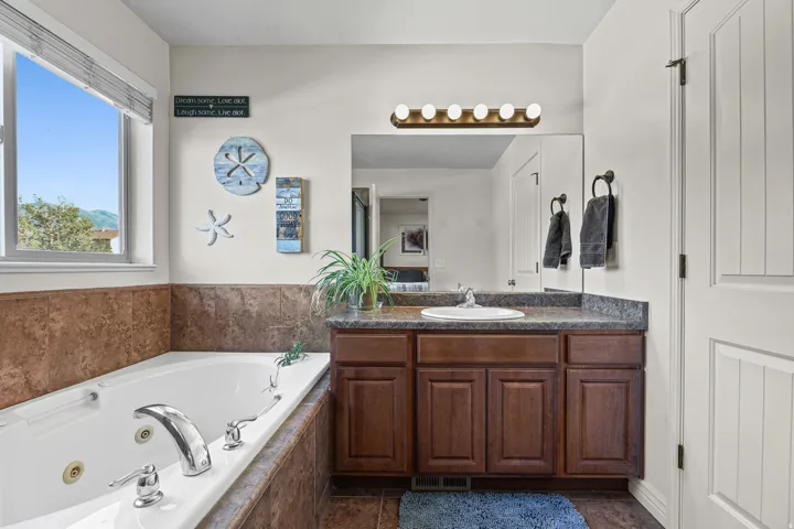 Soaking tub with chrome fixtures and tiled surround