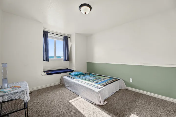 Carpeted room featuring a window with a built-in window seat, two-tone wall paint, white trim, and a semi-flush ceiling light fixture