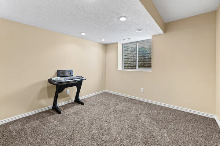 Carpeted room with recessed lighting and neutral wall paint