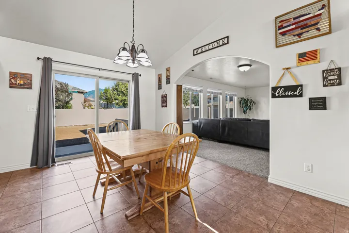 Spacious dining area featuring tile flooring and a decorative chandelier
