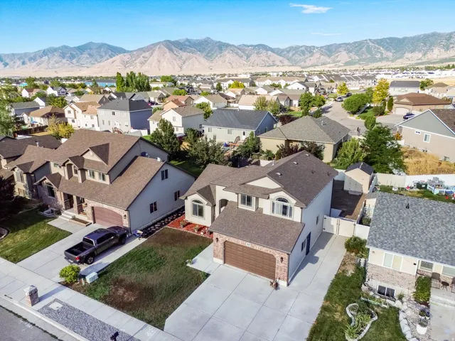 Traditional-style residence featuring a two-car garage, concrete driveway, and a front lawn