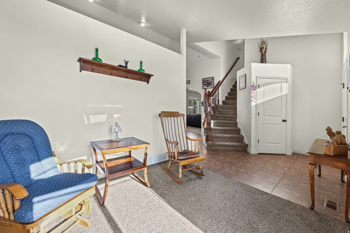 Foyer featuring a staircase with wood railing, recessed ceiling lighting, and tile flooring