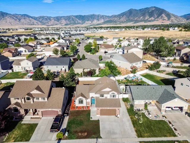 Suburban neighborhood featuring a variety of residential properties, paved streets, and mountain terrain in the background