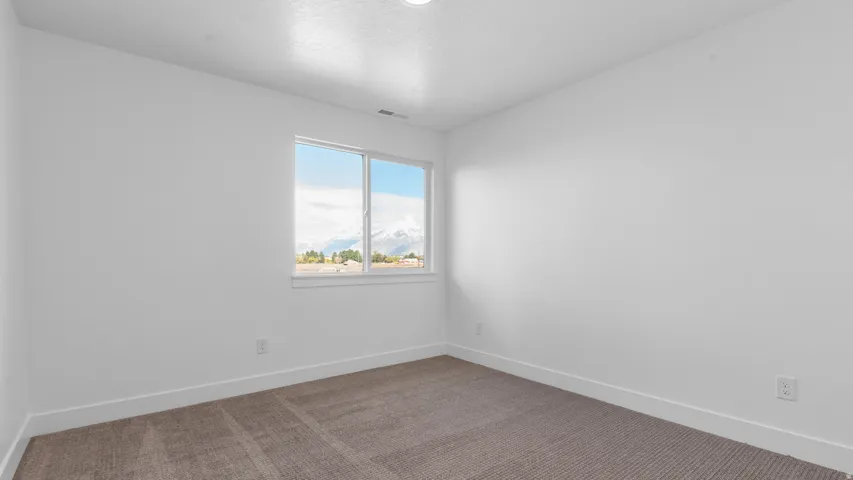 Neutral-toned carpeting and white walls in a spacious room