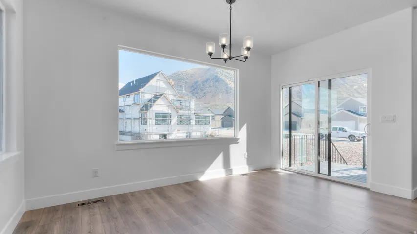 Open-concept living space featuring wood-finish flooring and bright white walls