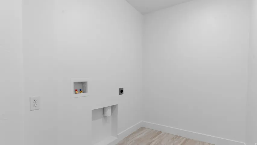 Dedicated utility space featuring a washing machine hookup, dryer vent, and electrical outlet