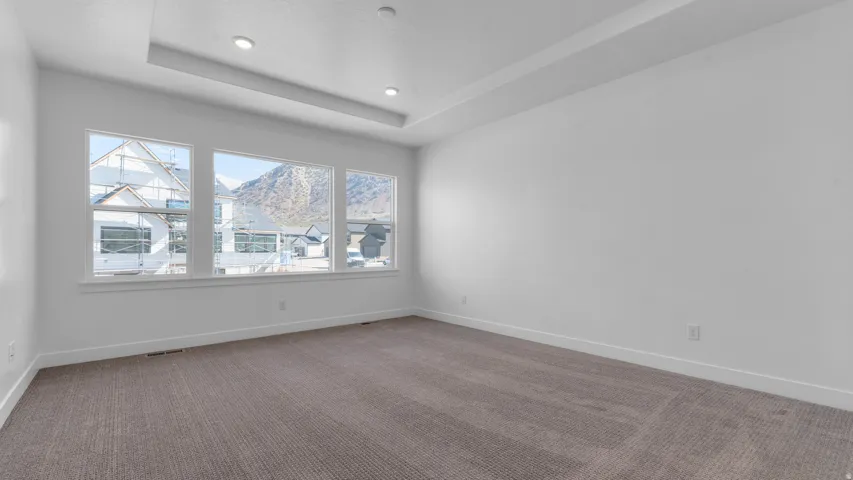 Spacious room featuring three large windows showcasing a mountain backdrop