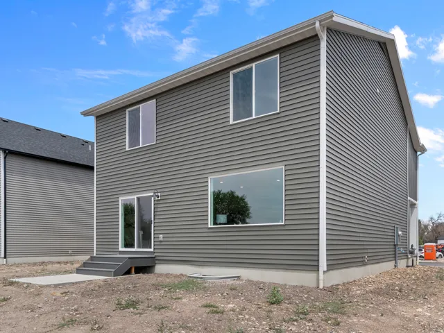 Two-story exterior featuring horizontal siding, multiple windows, and a sliding glass door