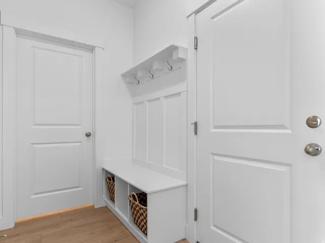 Entryway featuring a built-in bench with integrated storage cubbies, upper shelving, and coat hooks
