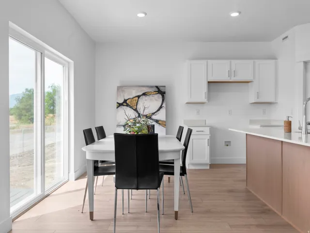 Bright interior featuring a spacious dining area with wood-finish flooring