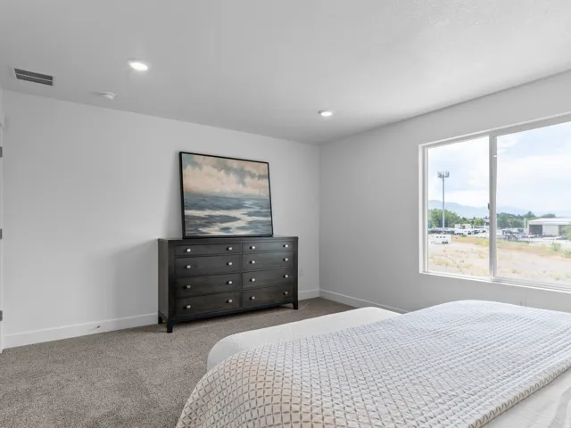 Bright room featuring a large window, recessed lighting, and carpeted flooring