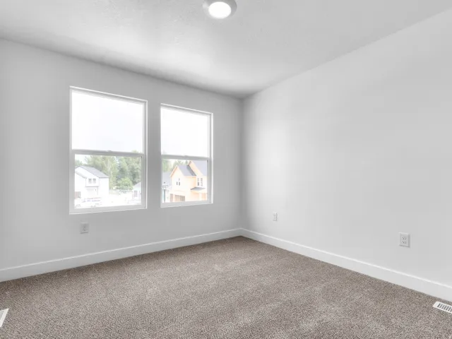 Room featuring neutral-toned carpet, white painted walls, and white baseboards