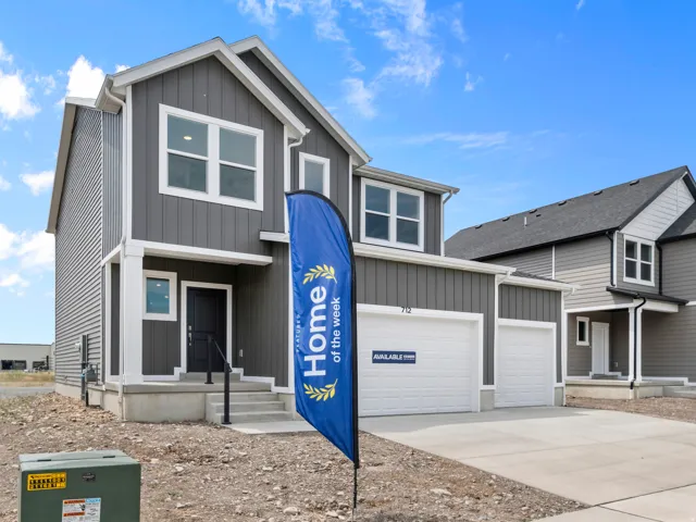 Contemporary two-story residence featuring a gray vertical siding facade and white trim accents