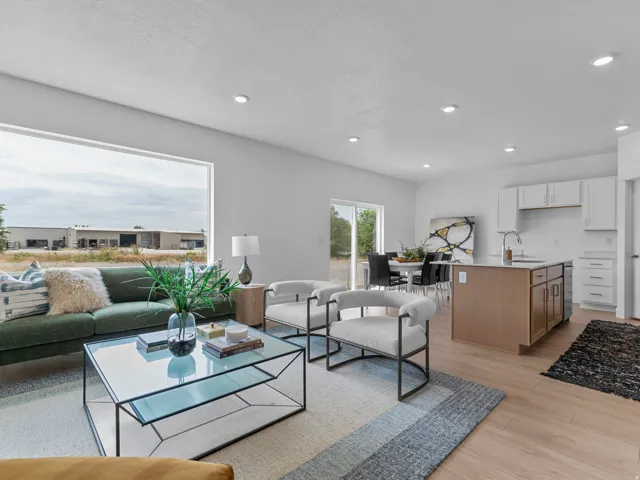 Open-concept interior featuring light wood-finish flooring, recessed lighting, and a prominent window