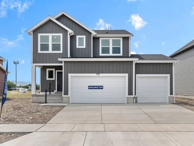 Modern facade with gray vertical and horizontal siding, white trim, and a prominent front entry