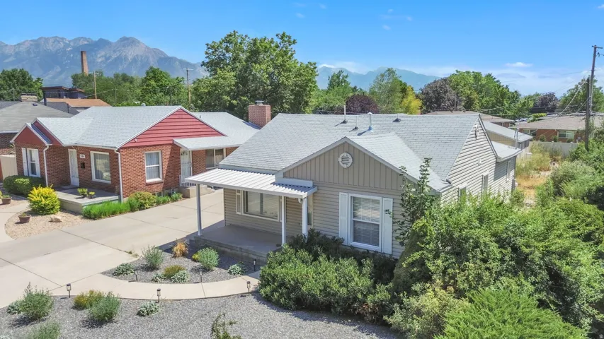 Ranch-style residence featuring siding exterior, an extended covered porch, and a gravel front yard with mature landscaping