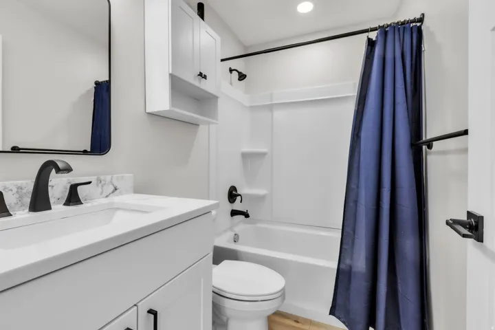 Bathroom featuring a modern vanity with white cabinetry and a white countertop, a rectangular undermount sink, and matte black fixtures
