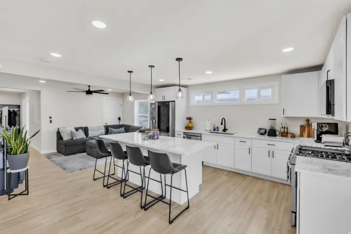 Open-concept living area featuring light wood-finish flooring, recessed lighting, and a contemporary ceiling fan