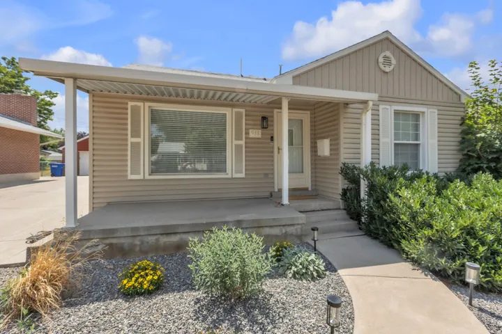 Single-story residence featuring light-colored siding, a covered front porch, and a concrete walkway