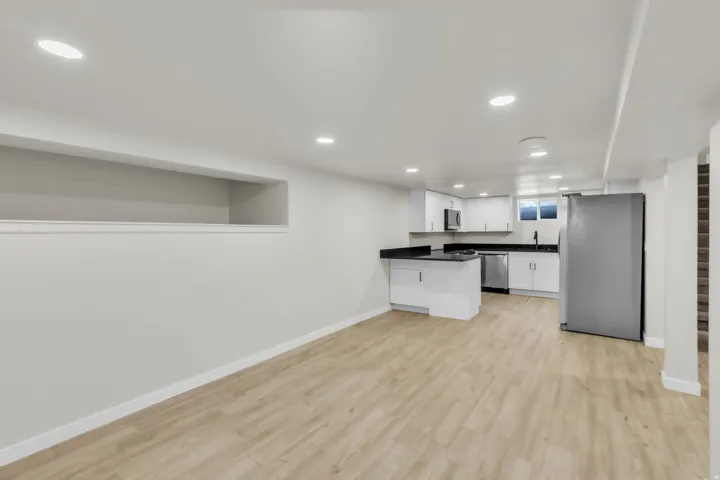 Open-concept living space featuring wood-finish flooring, recessed lighting, and a white baseboard trim