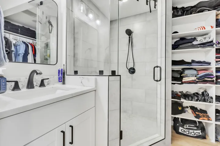 Contemporary bathroom featuring a glass-enclosed shower with a matte black shower system