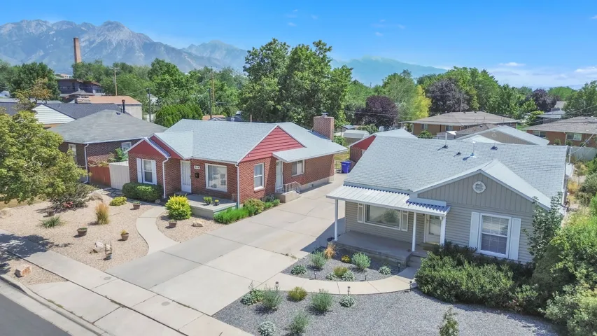 This property features a red brick residence with a white roof and an additional siding-clad home with a gabled roof