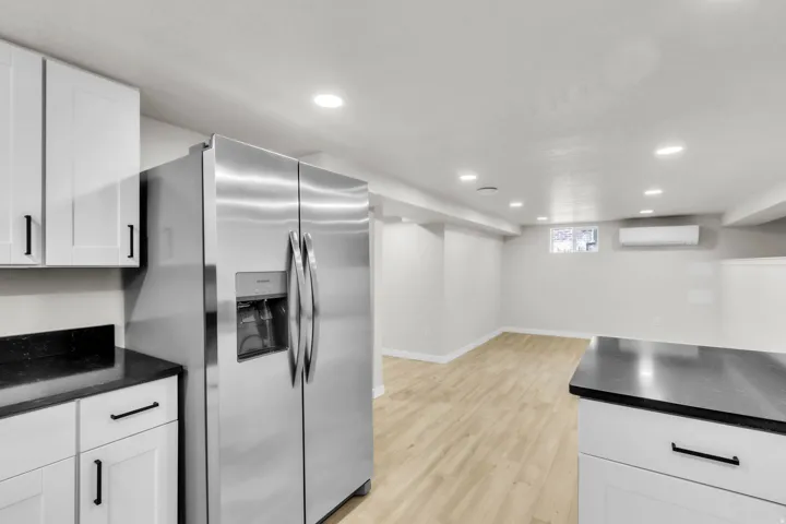 Stainless steel French door refrigerator with an ice and water dispenser, complemented by white shaker-style cabinetry
