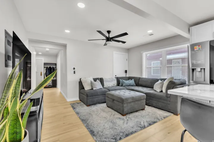 Open-concept living area featuring light wood-finish flooring, recessed lighting, and a contemporary ceiling fan