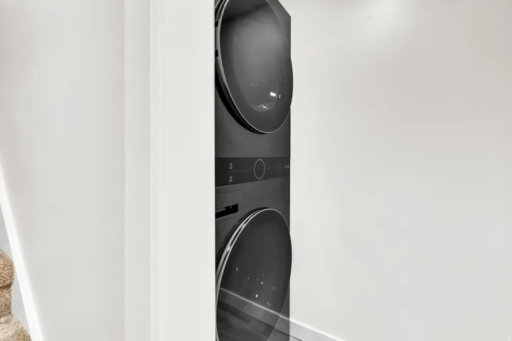 Full-size stacked laundry appliances with dark finish doors