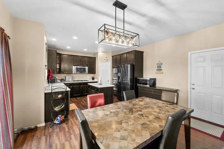 Open-concept kitchen and dining area featuring rich wood-finish flooring