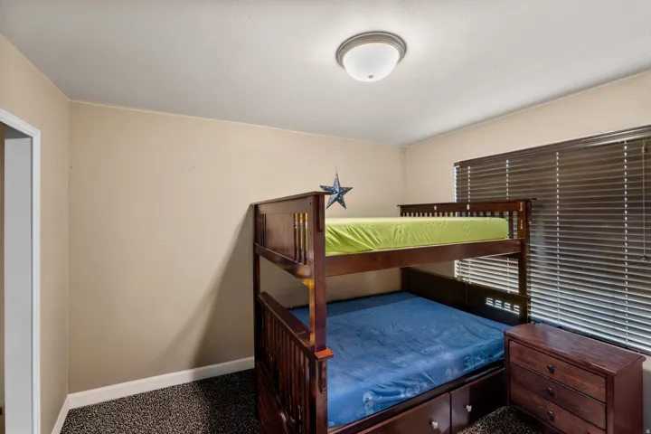 Interior room featuring neutral-toned walls, textured carpet flooring, and a ceiling-mounted light fixture