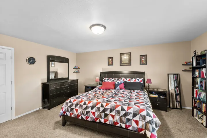 Carpeted room with neutral-toned walls, a white paneled door, and a flush-mount ceiling light fixture