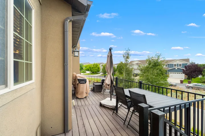 Expansive outdoor deck featuring wood-finish flooring and black metal railings