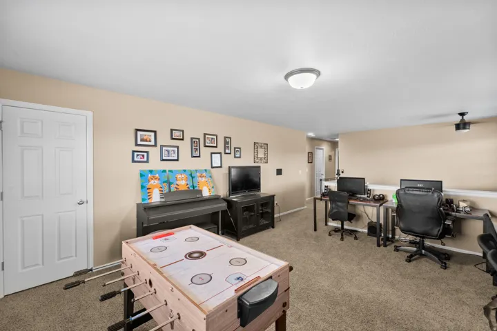 Carpeted room with neutral-toned walls, white trim, and a white six-panel door