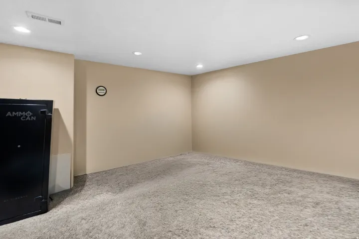 Spacious room with neutral wall tones and light-colored carpeting