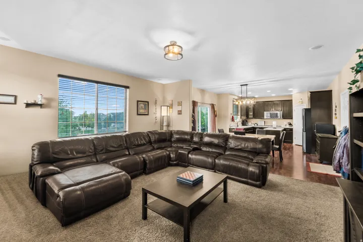 Bright living area featuring a large window with blinds and a ceiling light fixture