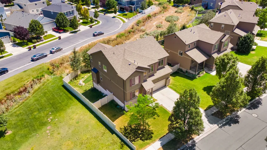 Two-story residence featuring a brown exterior, pitched shingle roof, and a two-car garage