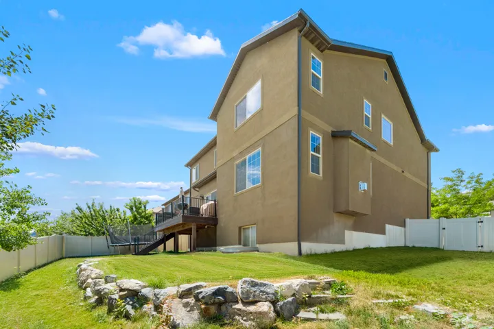 Multi-story stucco exterior with a durable dark-pitched roof