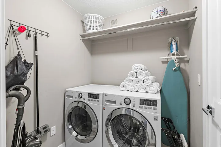 Dedicated laundry area featuring a built-in shelf, light gray wall paint, and white trim