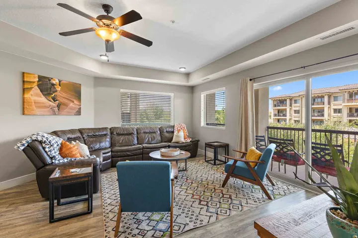 Living area featuring wood-finish flooring, a ceiling fan with integrated lighting, and recessed lighting